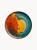 Widok z góry na płaski ceramiczny talerz pokryty żywym, artystycznym szkliwem, w którym ognisty pomarańczowy środek przechodzi w głęboki morski brzeg.
